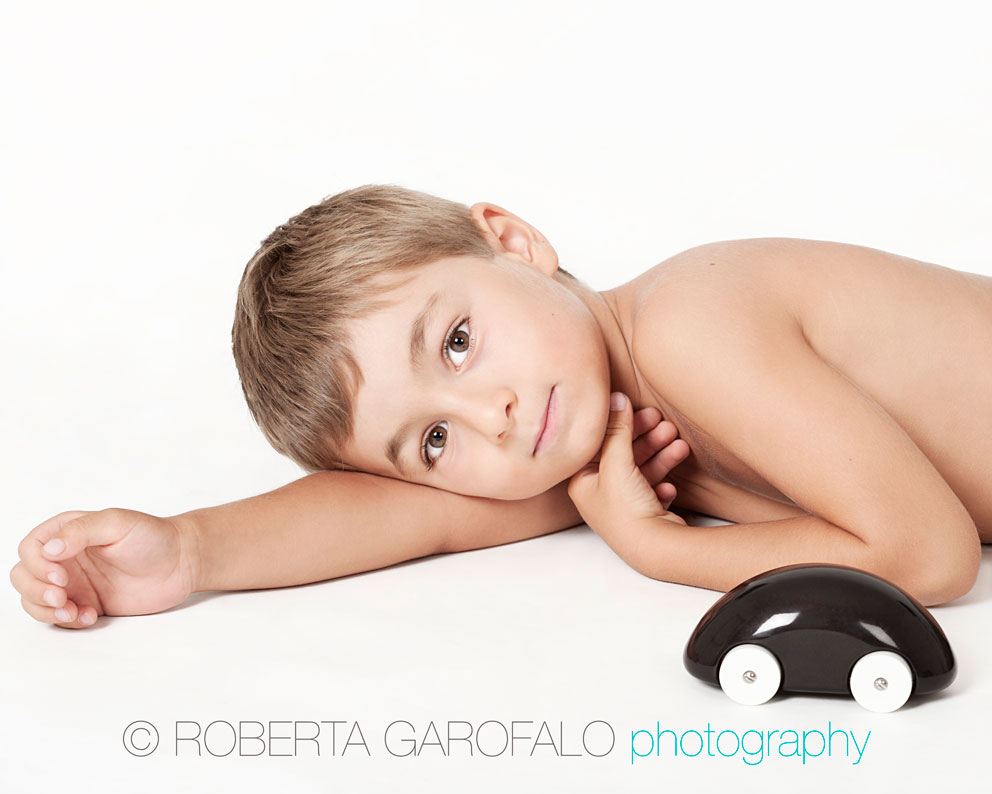 Fotografia di bambino con macchinina di legno