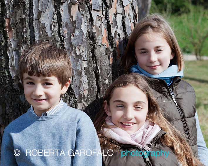 Fotografia di tre bambini intorno ad un albero