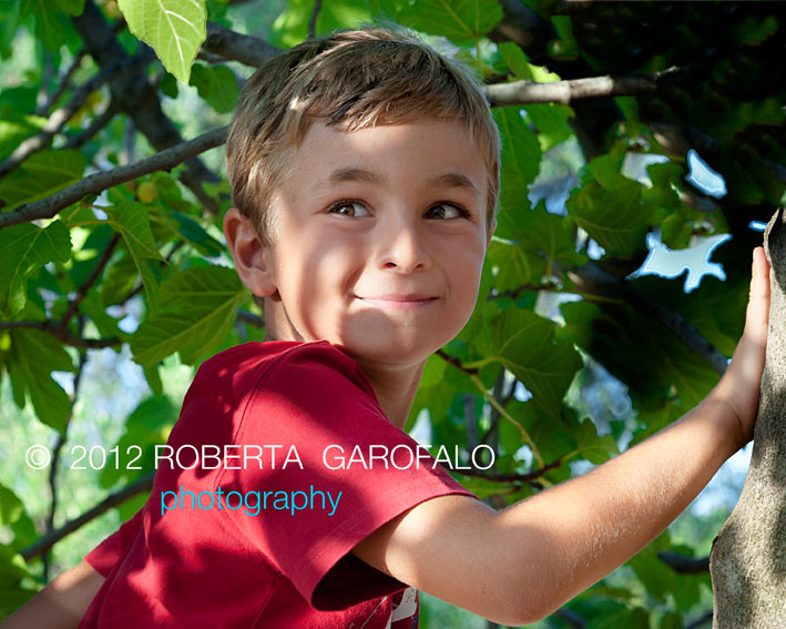 Fotografia di bambino che ride tra gli alberi