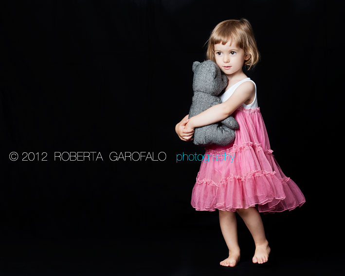 Fotografia bambina vestita di rosa con orsacchiotto